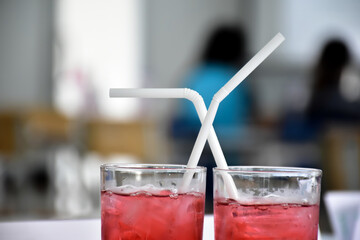 Glasses of soft drink on table with blurred background.