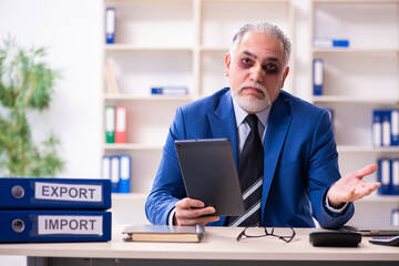 Old face injured employee sitting in the office