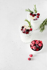 White cocktail with coconut milk, cranberry and rosemary alcoholic or moctail on white background