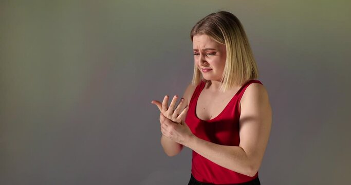 Eine h&uuml;bsche Blondine hat ihren Finger verbrannt. Es tut weh und sie blast am Finger, um ihn abzuk&uuml;hlen.
