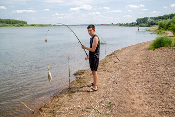 a fisherman pulls a fish on a warm summer day