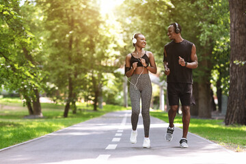 Obraz premium Relationship Goals. Black Couple Jogging Together In Morning Park, Enjoying Training Outdoors