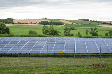 Beautiful sceenery of a little solar park in Bavaria, sourrounded by beautiful landscape in a little valley. Photograph was taken meanwhile sunset