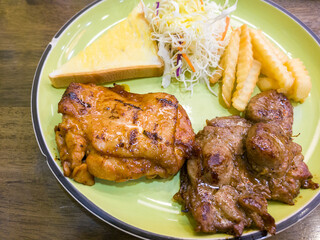 juicy grilled pork chop with french fries and salad greens and a sandwich
