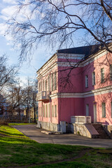 Fototapeta na wymiar Retro pink house in city park at sunset time in spring