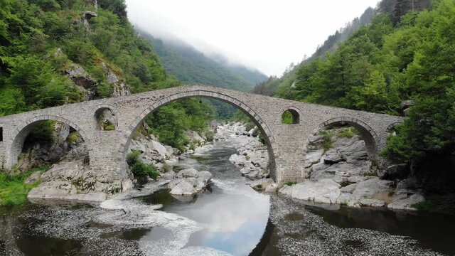 Roman Old stronework,devil bridge, from the ottoman on eastern europe, at Bulgaria. Medieval structure over the river in rhodope. Aerial view with drone of Mystic bulgarian location. Balkans valley