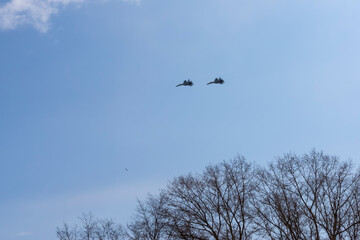 Two Russian military aircraft in the cloudy spring sky in the distance