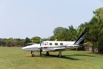Close up of a small two-engine plane parked on a grass field