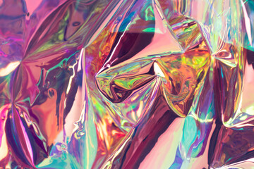 Multicolored blurred holographic backdrop. Iridescent wrinkled foil material. Psychedelic concept.