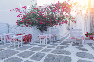 Streetview of Mykonos with whitewashed walls and restaurants and windows, Greece. Travel and tourism concept.