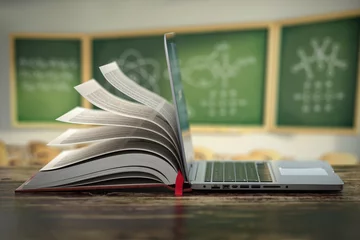 Fotobehang E-learning online education or internet  encyclopedia concept. Open laptop and book compilation in a classroom. © Maksym Yemelyanov