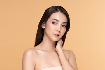 Beautiful Asian young woman touching neck smile with clean and fresh skin Happiness and cheerful with positive emotional,isolated on Beige background,Beauty and Cosmetics Concept