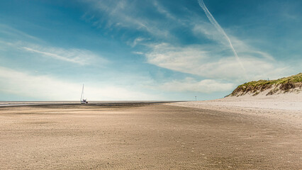 ein Segelboot an einem einsamen Sandstrand