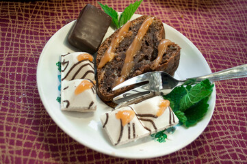 portion of chocolate pie with candies on a burgundy tablecloth