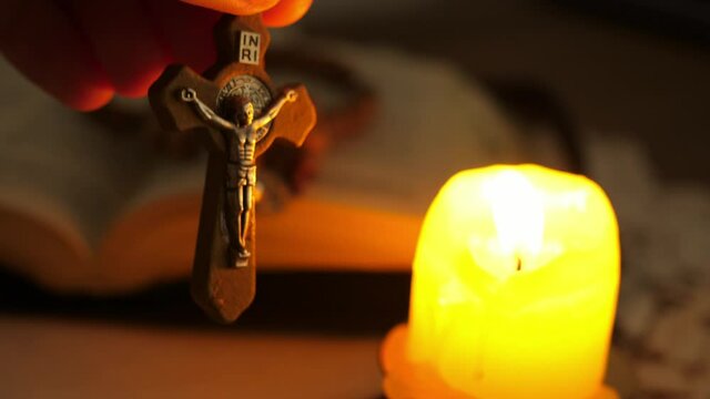 cross with Christ Jesus in twilight illuminated by candle light
