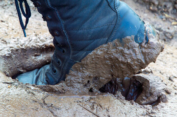 military boot stuck in wet and sticky mud