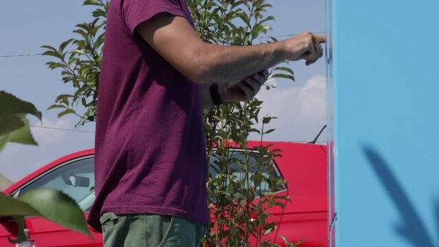 Return to sender. Caucasian man puts a package into a hub locker for the courier. E commerce concept, return to sender shipment
