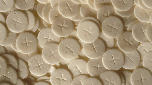 communion hosts sacramental breads turning round rotating flat lay top view