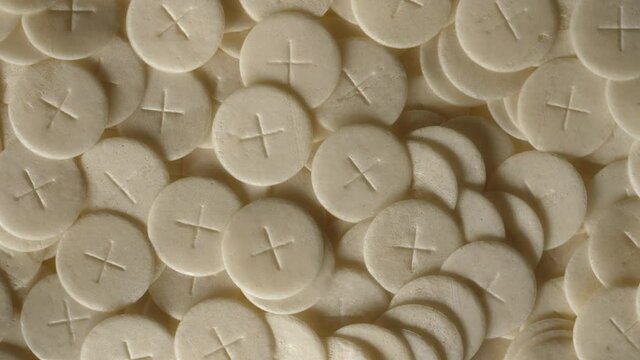 communion hosts sacramental breads turning round rotating flat lay top view