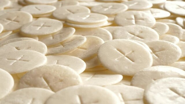 communion hosts sacramental breads turning round rotating flat lay top view