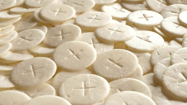 communion hosts sacramental breads turning round rotating flat lay top view