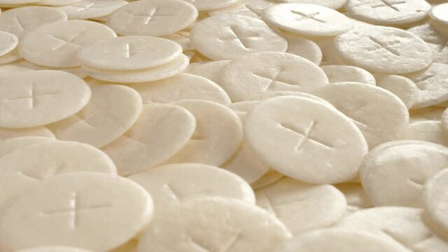 communion hosts sacramental breads turning round rotating flat lay top view