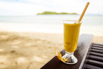 Mango juice on in front of the tropical sea