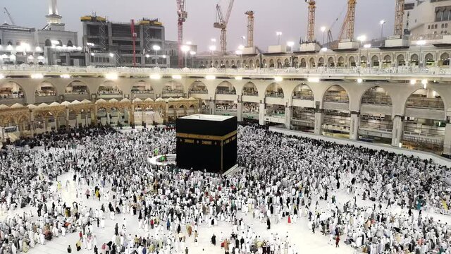 Time lapse of Muslim pilgrims circling around the holy Kaaba at dawn and praying inside Al Haram Mosque in Mecca, Saudi Arabia.