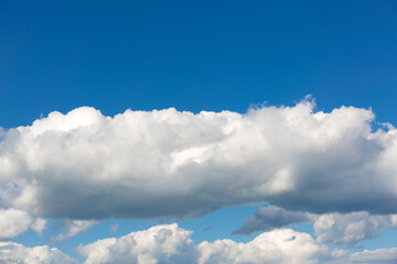 Naklejka na ściany i meble Gray clouds on blue sky background.