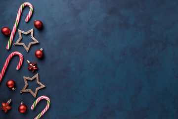 Composition of festive decorations, candies and gift boxes on dark background with copy space for text design