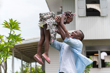 Fototapeta premium Happy african american Father and Daughter child girl play throws airplane enjoying active with outside house background.