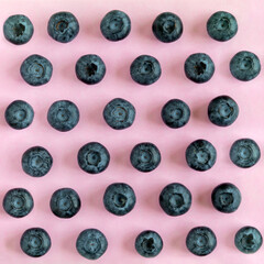 Fresh organic blueberries on pink background. View from above, square format