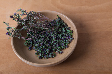Raw Organic Thyme in a wooden Bowl on wooden table. Top view.
