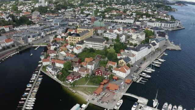 The City Of Arendal And The Trinity Church With Waterfront Houses, Buildings And Moored Boats By The Norwegian Coast In Agder, Norway.  - aerial drone