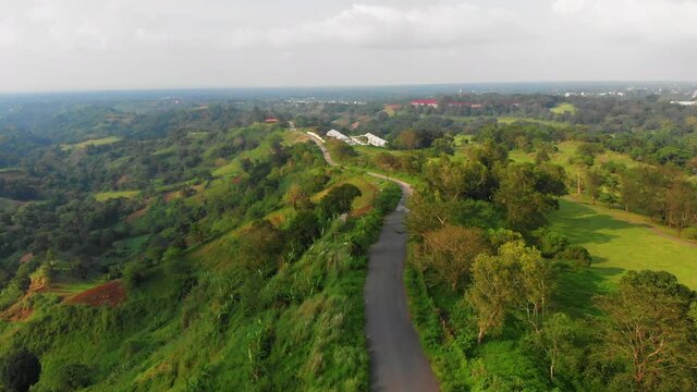 Reverse aerial reveal of mountain road and stunning Nasugbu landscape