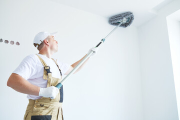 Painter works with triangle drywall cleaning tool. Surface preparation for painting