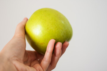 ripe fresh green apple in female hand, healthy food concept, vegetarian diet.