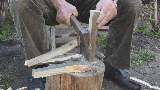 Rąbanie drewna na opał. Siekiera w dłoniach. 
