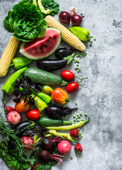 Garden organic vegetables, berries, fruits on a gray background, top view. Healthy diet vegetarian food concept. Flat lay, copy space