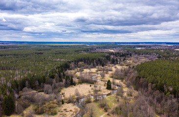 Drone shot flying on spring river in forest