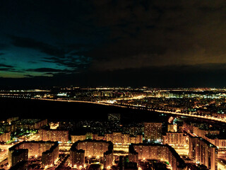 Drone overlooking the city at night, lit streets and dark sky