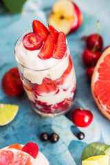 Dessert with raspberry, ice cream, berry and grapefruit on blue table