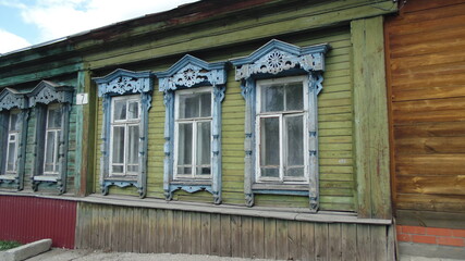 Carved platbands on the wooden windows of the old house. Architecture, facade decoration.