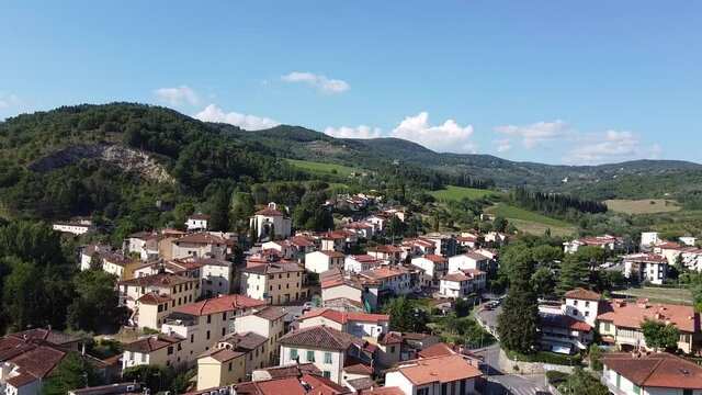 Approaching aerial overview of Molin del Piano, ancient town near Arno river valley. South Florence area near Pontassieve, Tuscany Italy. Mid summer cloudy day at sunset