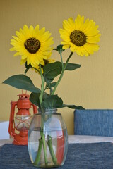 sunflowers in a vase on the table and a lantern