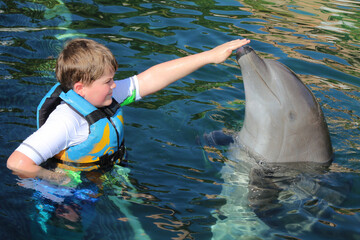 BOY SWIMMING WITH DOLPHIN