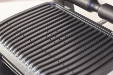 Ridge teflon surface of an electric grill. Close-up view of barbecue for home use. - 368845133