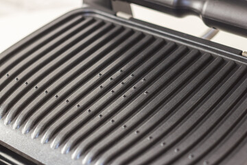 Ridge teflon surface of an electric grill. Close-up view of barbecue for home use. - 368845149