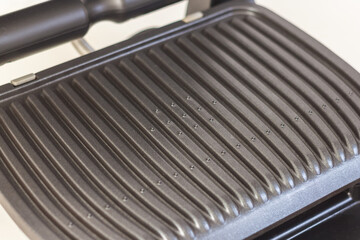 Ridge teflon surface of an electric grill. Close-up view of barbecue for home use. - 368845155
