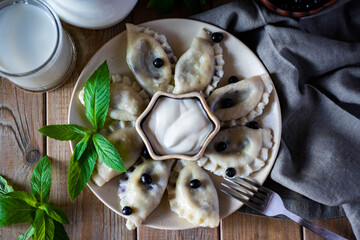 Dumplings with blueberries on a plate on a wooden table. Type of superu